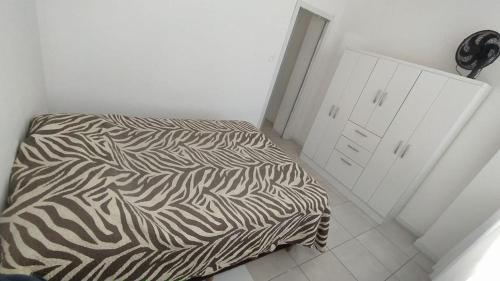 - un lit noir et blanc dans une chambre blanche dans l'établissement Coração de Balneário Camboriú, à Balneário Camboriú