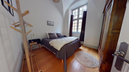 um quarto com uma cama e piso em madeira em Le Prieuré em Dole