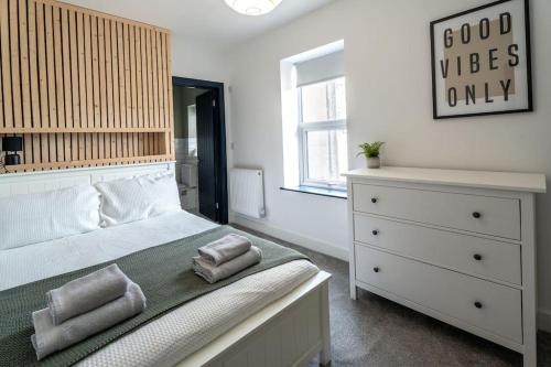 ein Schlafzimmer mit einem Bett und einer Kommode mit Handtüchern darauf in der Unterkunft Luxury in the City Centre 2 Bed by Home Host in Cardiff