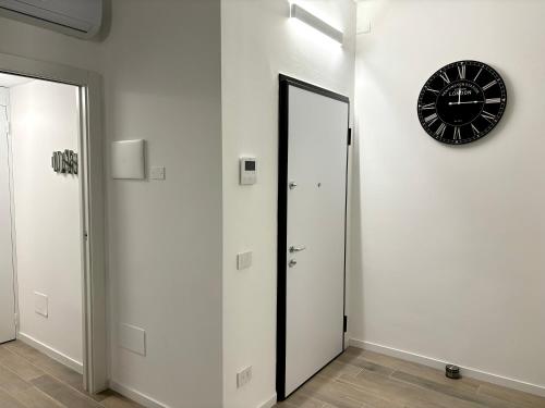 a clock on a wall next to a hallway with a door at Modern-House • Fiera Milano (MiCo) • City Life in Milan