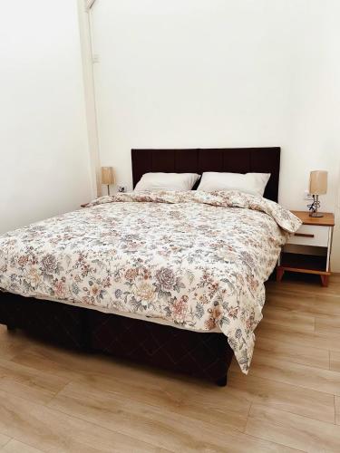 1 dormitorio con 1 cama con edredón de flores en Rococo Apart en Montevideo