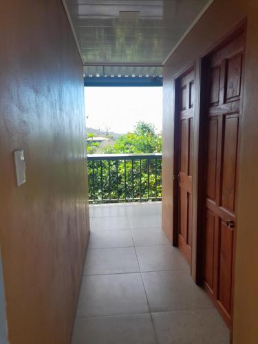 un pasillo con puertas y vistas a un balcón en Casa árbol, en Aguas Zarcas