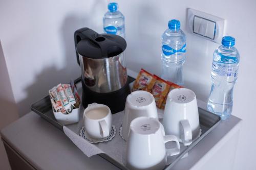 a tray with cups and water bottles on a counter at Nile Guardian Hotel in Cairo