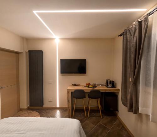 Habitación con escritorio, cama y TV. en Lucalì Mountain Room, en Ponte di Legno