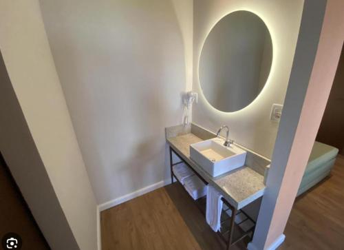 a bathroom with a sink and a mirror at Hot Beach Suites in Olímpia