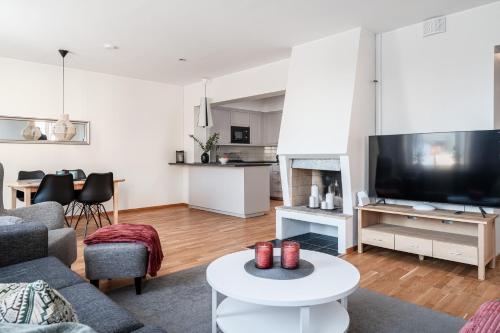 a living room with a couch and a tv at Guestly Homes - 3BR City Charm in Piteå