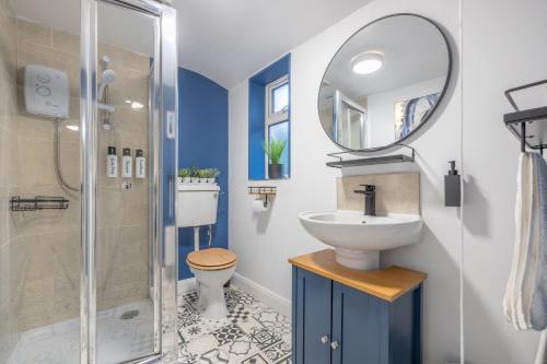 uma casa de banho com um lavatório, WC e um espelho. em Violet Suite Apartments em Derry Londonderry