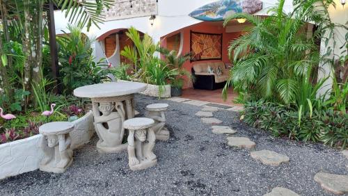 una mesa y taburetes frente a una casa en Hotel y Restaurante Mama Ines en Santa Catalina