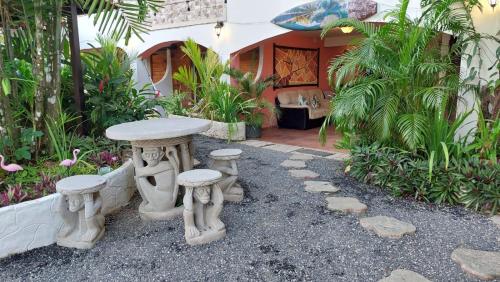 a table and stools in front of a house at Hotel y Restaurante Mama Ines in Santa Catalina