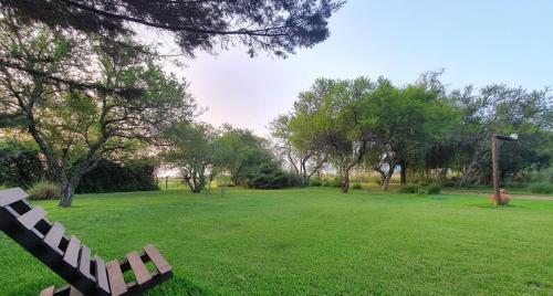 a park with a bench in the middle of a field at Valdemoro Hosteria in Gualeguaychú