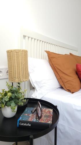 a table with a book on it next to a bed at Apartament a Sant Celoni, Montseny, Barcelona in San Celoni
