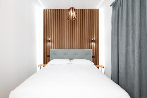 a bedroom with a white bed and a wooden headboard at Green Room in Zadar