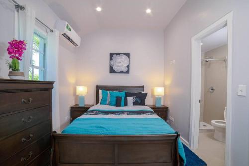 Blue Haven (Mercy's Place) في Buckleys: غرفة نوم بسرير وملاءات زرقاء وحمام