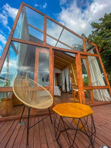 a glass house with a chair and a table at NaturalMente Glamping in San Antonio del Tequendama