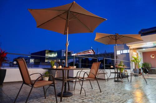 a patio with a table and chairs and umbrellas at Casa Cheljo in Guadalajara