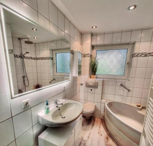 y baño con lavabo, bañera y aseo. en Ferienhaus mit Sauna, Whirlpool und Garten, en Wuppertal