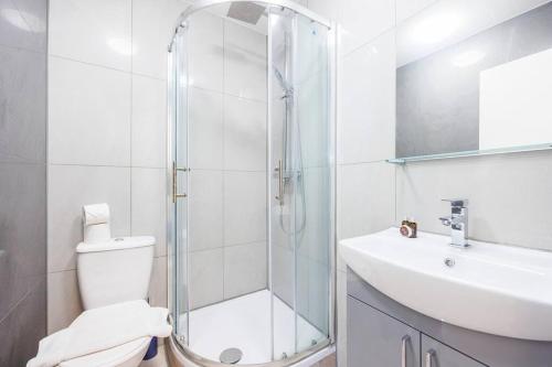 a bathroom with a shower and a toilet and a sink at North West London Studio Apartment By AV Stays Short Lets London in London