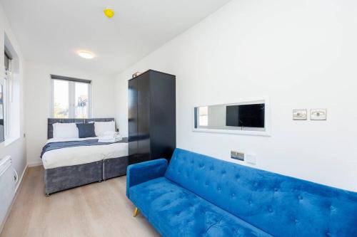 a living room with a blue couch and a bed at North West London Studio Apartment By AV Stays Short Lets London in London