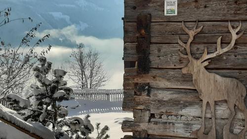 a statue of a deer on the side of a building at Almhütte Brandgut in Mühlbach am Hochkönig