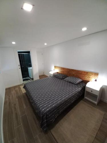 a bedroom with a large bed with a wooden headboard at Terraços da Serra in Painho