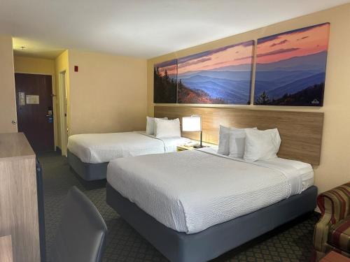 una habitación de hotel con 2 camas y un cuadro en la pared en Days Inn & Suites by Wyndham Eunice, en Eunice