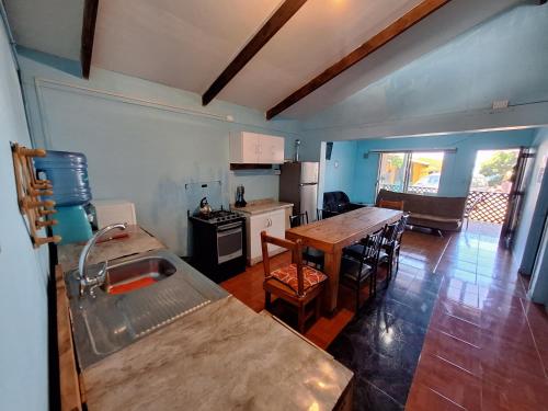 a kitchen with a table and a dining room at Cabañas puna poho in Hanga Roa