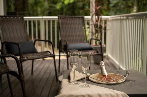 a table with two wine glasses on a deck at Holzhaus Blumenau in Blumenau