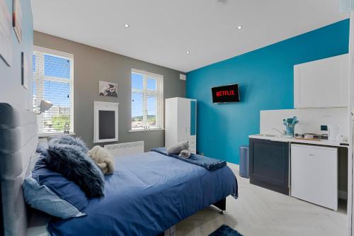 a bedroom with a bed and a blue wall at West Five, Double Bedroom Suite with Private Bathroom in London