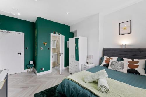 a bedroom with green and white walls and a bed at West Five, Double Bedroom Suite with Private Bathroom in London