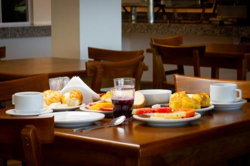 een houten tafel met borden met eten erop bij Pousada Gammel Dansk by Latitud Hoteles in Búzios