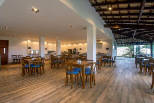 a dining room with wooden tables and chairs at Pousada Gammel Dansk by Latitud Hoteles in Búzios