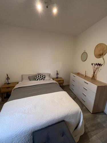 une chambre avec un grand lit et une commode dans l'établissement Ibiscus-Immoploc, à Dieppe