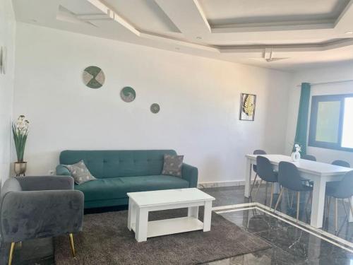 un salon avec un canapé vert et une table dans l'établissement L’écho des vagues, à Dakar