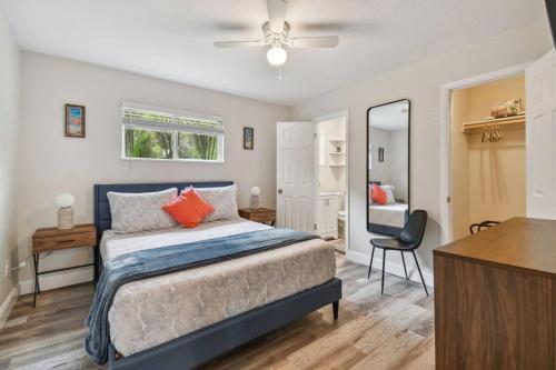 a bedroom with a bed and a desk and a mirror at Chic & Cozy 3 Bed/2 Bath House Near Beaches in Largo