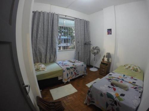 Habitación pequeña con 2 camas y ventana en Sunset Oasis no coração da Zona Sul!, en Río de Janeiro