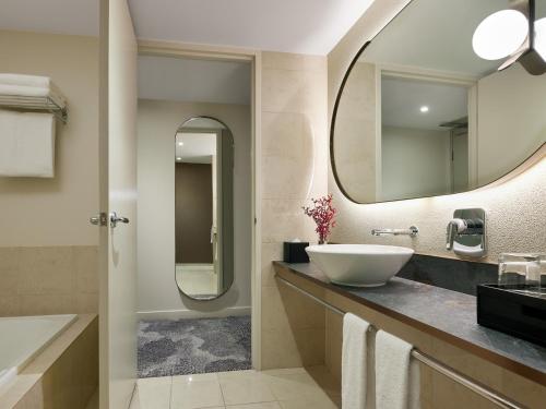 uma casa de banho com um lavatório e um espelho em PARKROYAL Melbourne Airport em Melbourne
