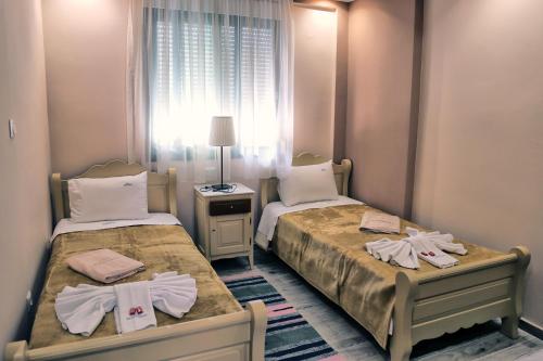 two beds in a small room with a window at Hotel Dionysos Polichrono in Polykhrono