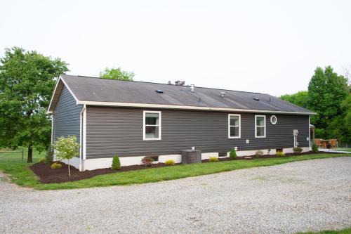 a gray house with a gravel driveway at Maple Retreat with Big Pool in Dundee