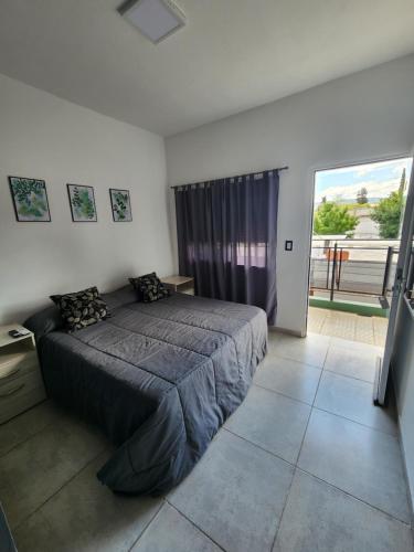 a bedroom with a bed and a large window at MAKTUB DEPARTAMENTOS Y HABITACIONES in Alta Gracia