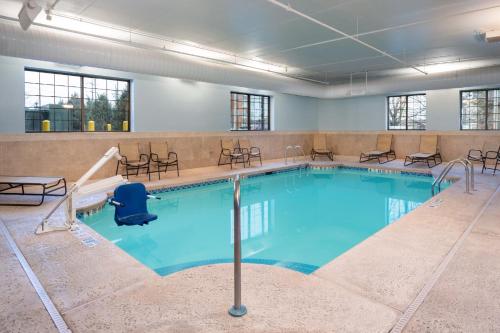a large swimming pool with chairs and tables at Staybridge Suites Buffalo-Amherst by IHG in Amherst