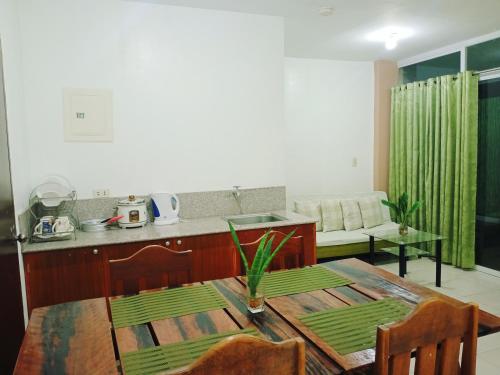 a kitchen and dining room with a wooden table and a tableablish at Mariana Condotel in Puerto Princesa City