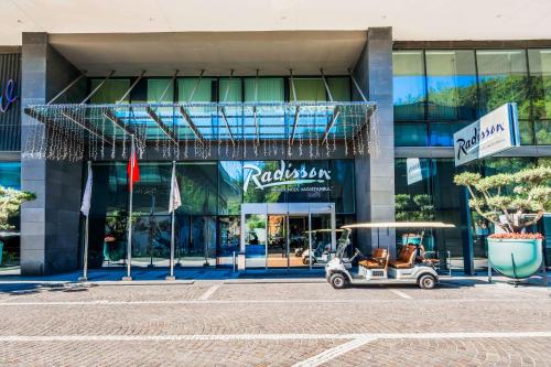 wózek golfowy zaparkowany przed budynkiem w obiekcie Radisson Residences Vadistanbul w Stambule