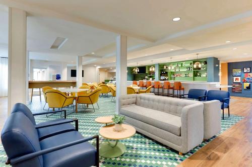 a lobby with a couch and chairs and tables at Sonesta Select San Francisco Airport Oyster Point Waterfront in South San Francisco