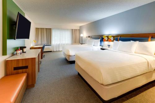 a hotel room with two beds and a flat screen tv at Sonesta Select San Francisco Airport Oyster Point Waterfront in South San Francisco