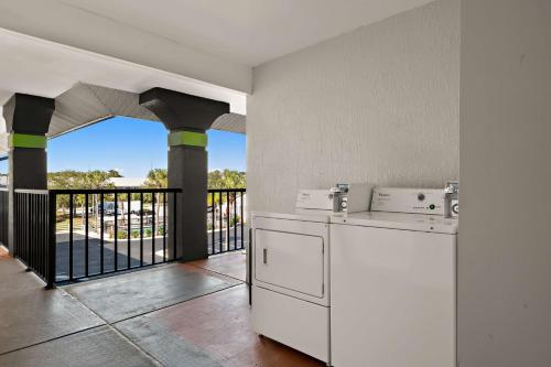 a kitchen with white appliances and a balcony at SureStay Hotel by Best Western Clermont Theme Park West in Kissimmee