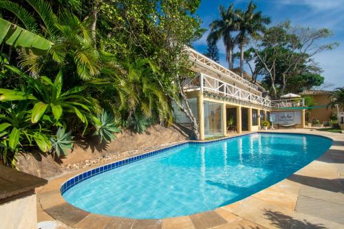a swimming pool in front of a house at Pousada e Spa Villa Mercedes by Latitud Hoteles in Búzios