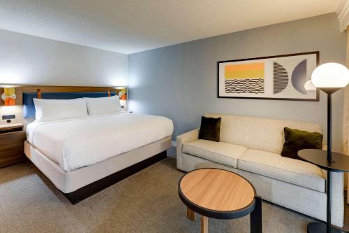 a hotel room with a bed and a couch at Sonesta Select San Francisco Airport Oyster Point Waterfront in South San Francisco