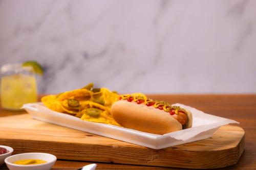 a hot dog and chips on a plate on a table at Drury Plaza Hotel Tallahassee in Tallahassee