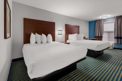 a hotel room with two beds and a desk at SureStay Plus by Best Western Brooks in Brooks