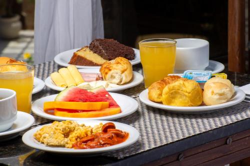 a table with plates of breakfast foods and drinks at Pousada e Spa Villa Mercedes by Latitud Hoteles in Búzios